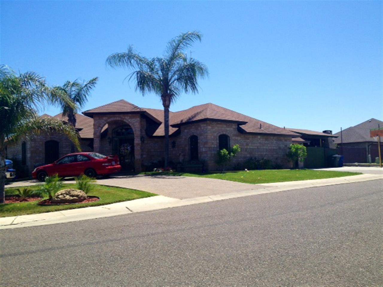 a house with a yard and a table and chairs under an umbrella