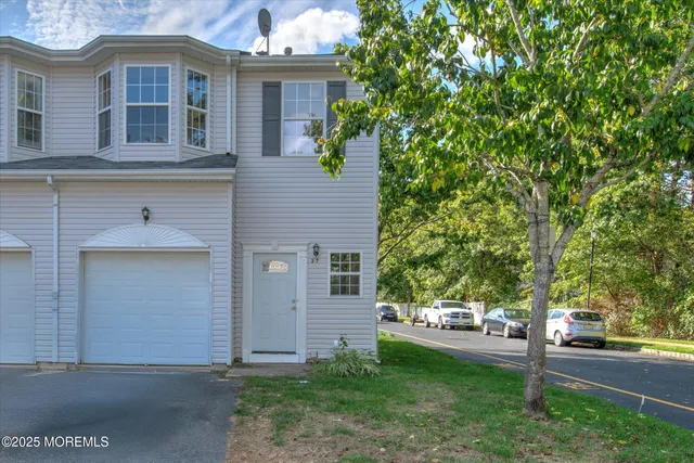 a view of a house with a tree in front of it