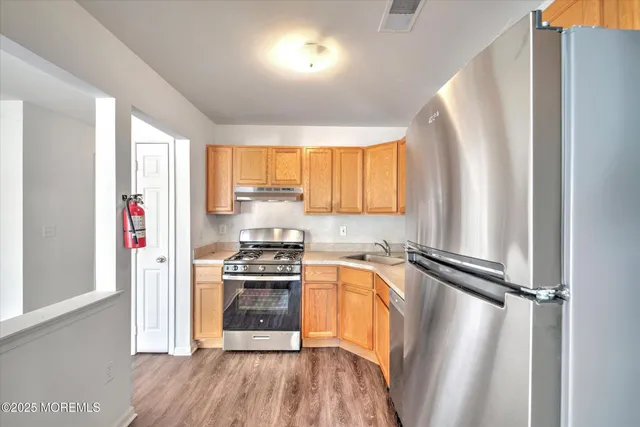 a kitchen with a refrigerator a sink and a window