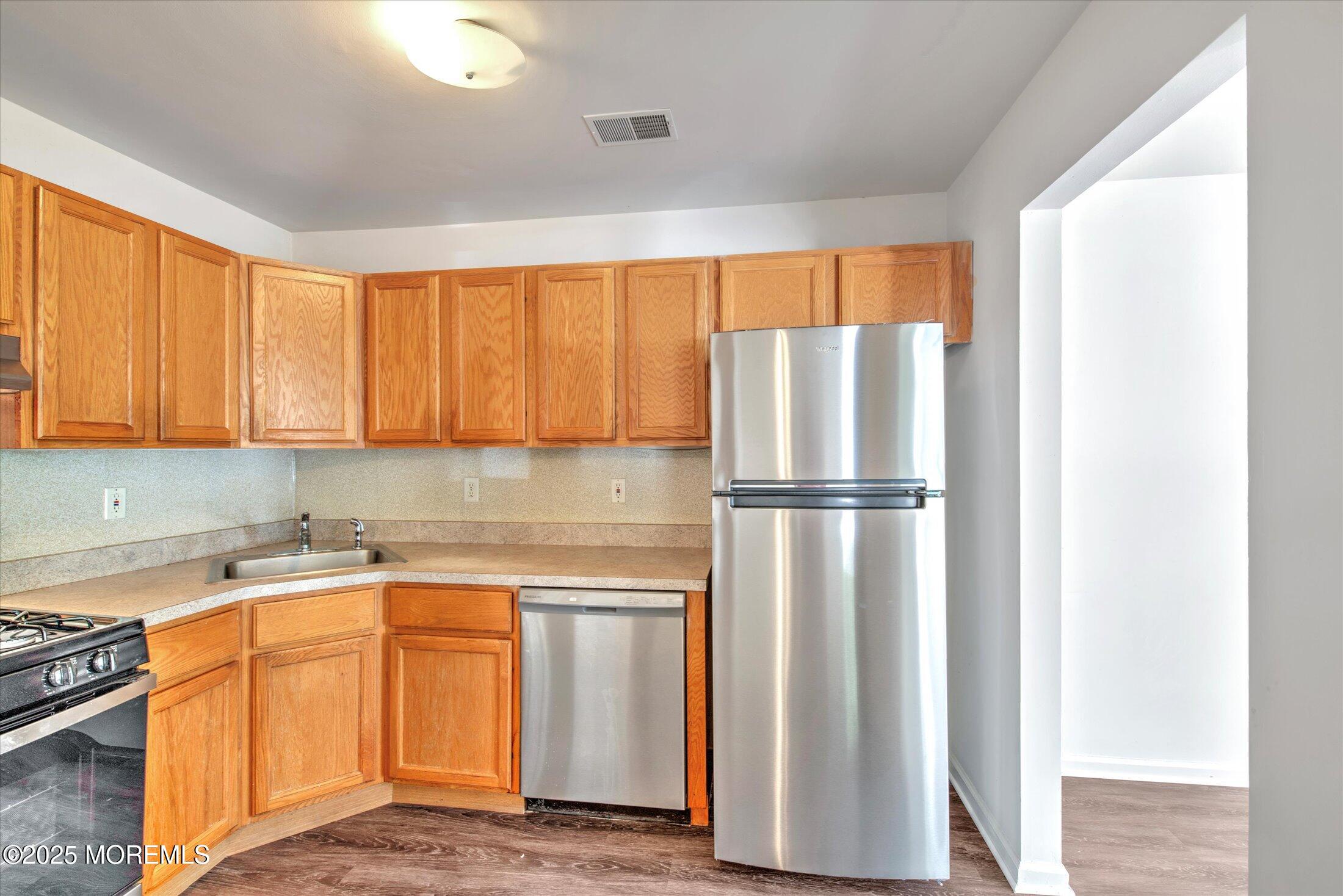 1 Esplanade Way Bayville, NJ 08721 - Photo 16 of 41 a kitchen with a refrigerator sink and cabinets
