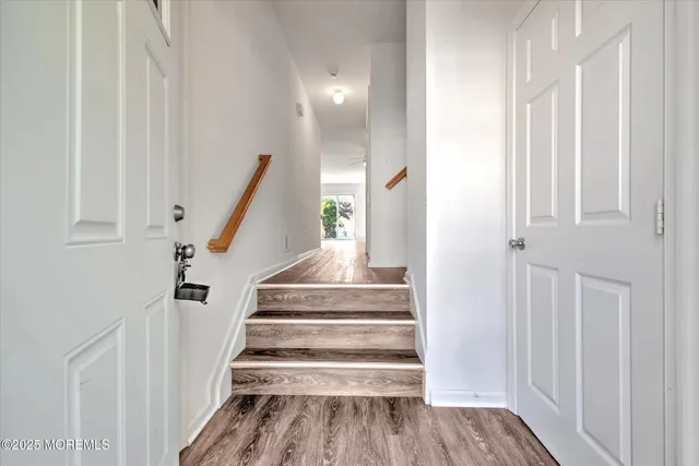 a view of a hallway with wooden floor and staircase