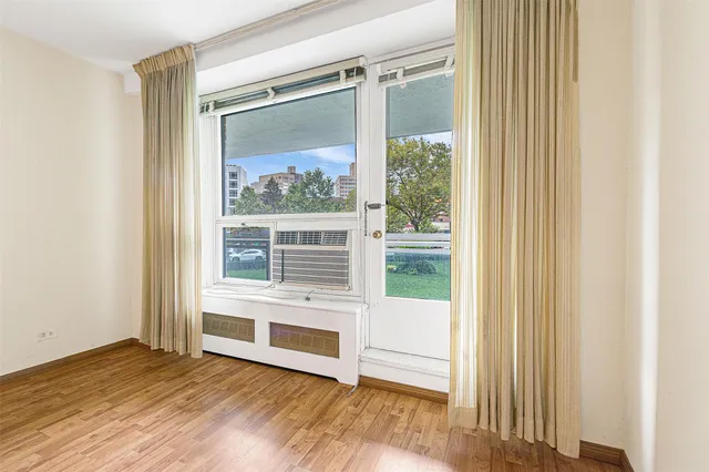 a view of a bedroom with wooden floor and a window
