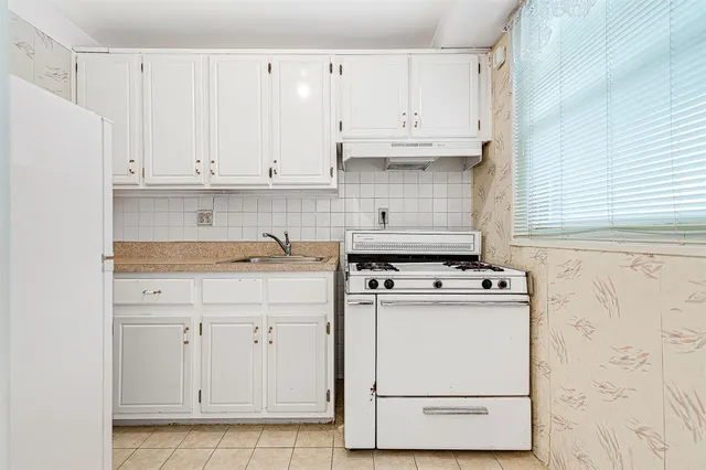a kitchen with white cabinets and white appliances