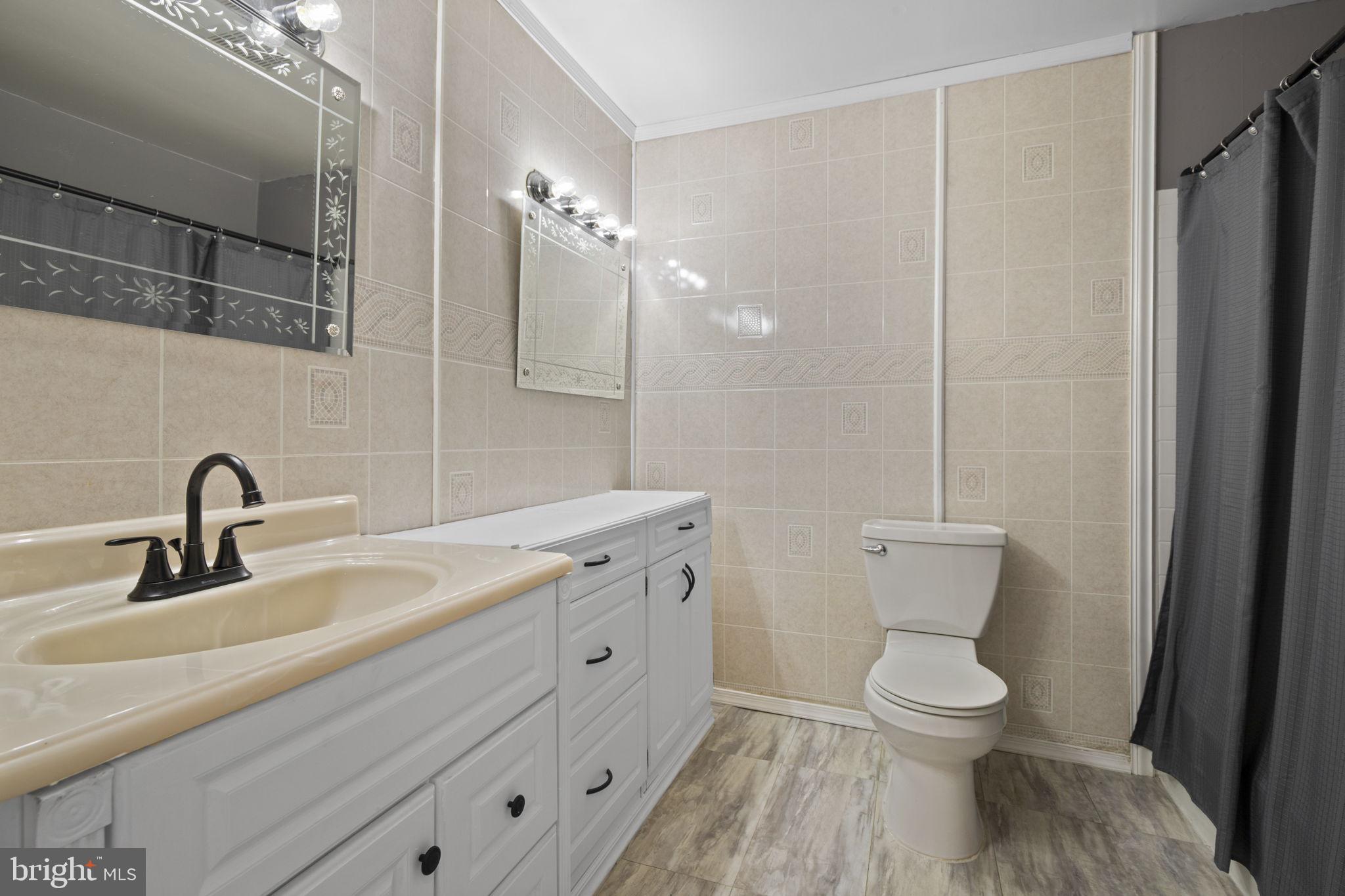 1775 Pleasantville Road Forest Hill, MD 21050 - Photo 14 of 35 a bathroom with a toilet sink and mirror