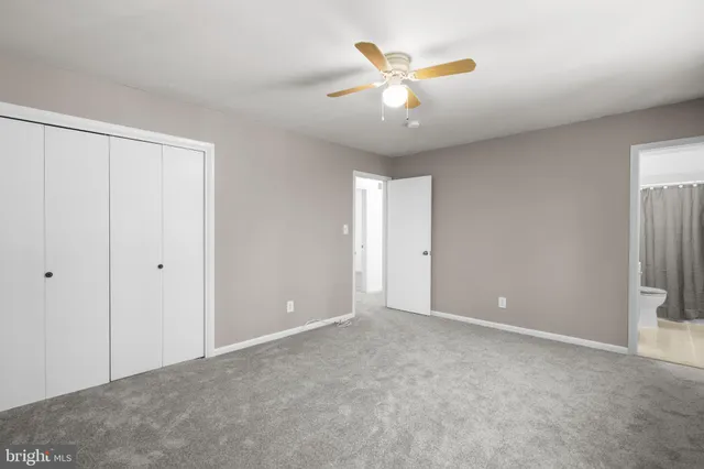 an empty room with closet and a chandelier fan
