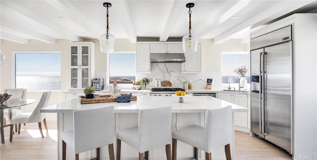329 21st Place Manhattan Beach, CA 90266 - Photo 2 of 18 a kitchen with stainless steel appliances a table chairs and a refrigerator