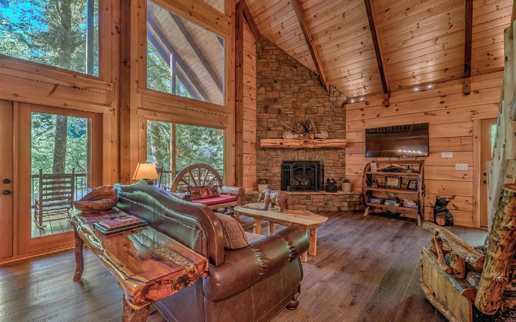 343 Muller Lane Ellijay, GA 30540 - Photo 12 of 35 a living room with furniture a fireplace a flat screen tv and a large window