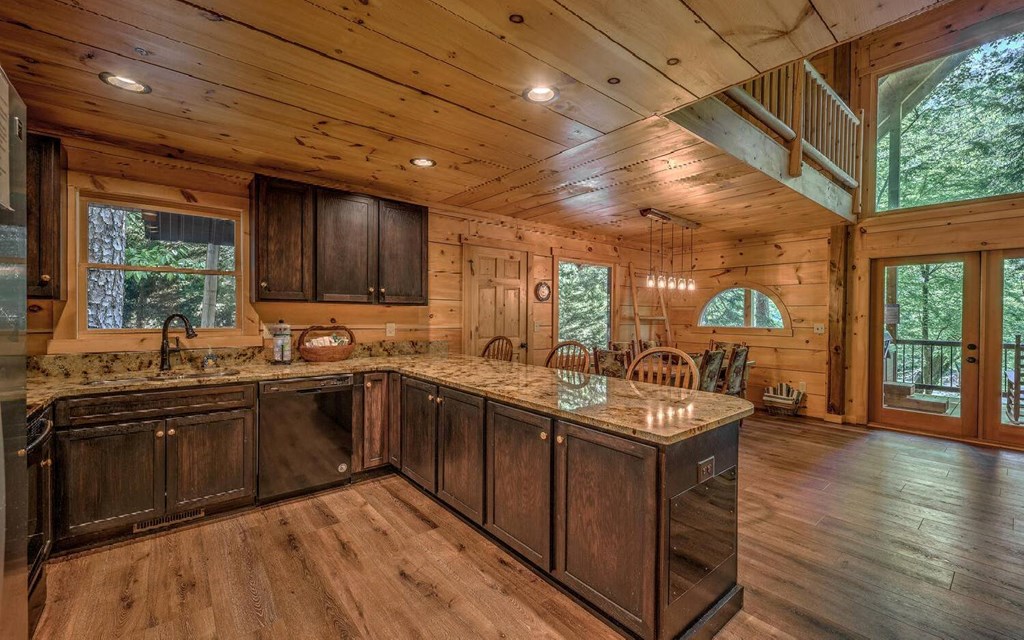 343 Muller Lane Ellijay, GA 30540 - Photo 15 of 35 a kitchen with stainless steel appliances granite countertop hardwood floor sink stove dining table and chairs