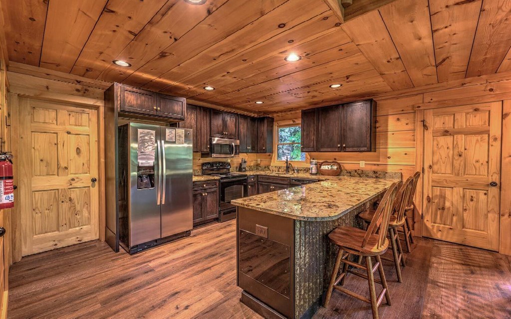 343 Muller Lane Ellijay, GA 30540 - Photo 16 of 35 a kitchen with stainless steel appliances granite countertop a table chairs stove and refrigerator
