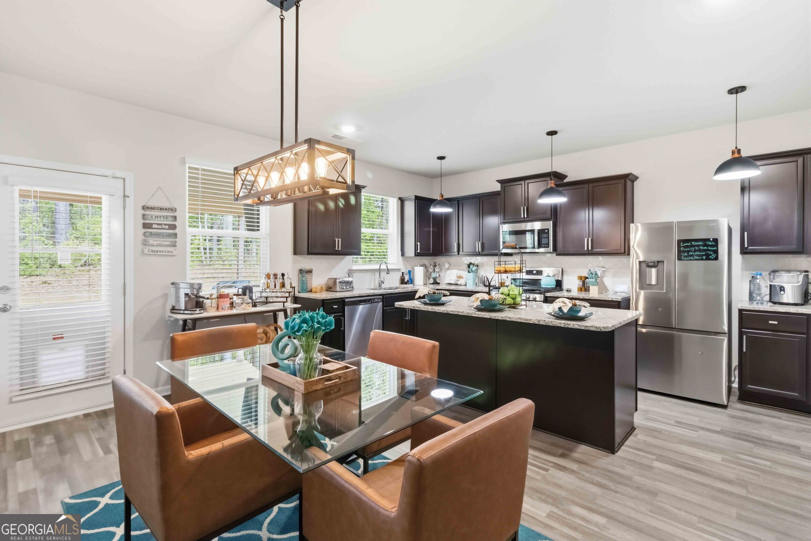 386 Paden Way Jonesboro, GA 30238 - Photo 10 of 29 a kitchen with stainless steel appliances granite countertop a refrigerator a stove top oven a sink dishwasher and a dining table with wooden floor