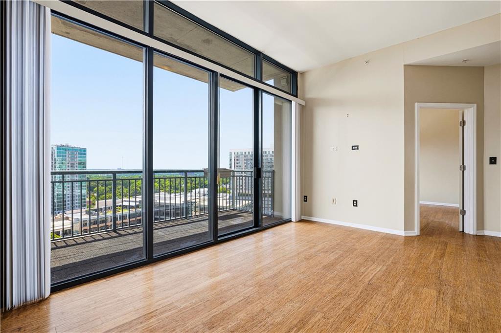 3040 Peachtree Road Northwest, Unit 1503 Atlanta, GA 30305 - Photo 11 of 38 a view of an empty room with wooden floor and iron stairs