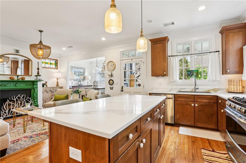 a large kitchen with stainless steel appliances a large counter space and a view of living room