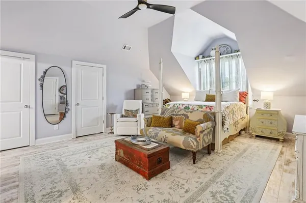a bedroom with a bed and a flat tv screen on dresser
