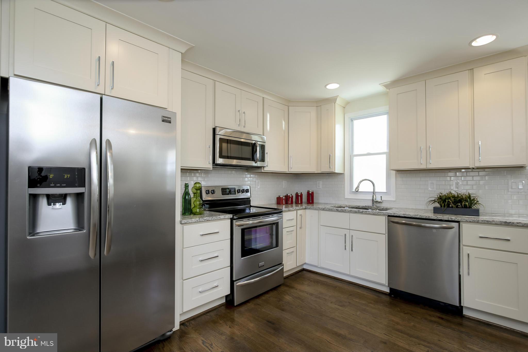 3313 Chapman Road Randallstown, MD 21133 - Photo 6 of 30 a kitchen with a refrigerator a sink a stove a microwave and cabinets