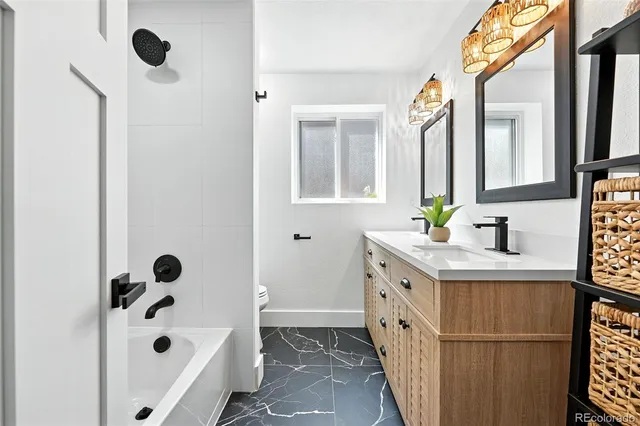 a bathroom with a double vanity sink a mirror and bathtub