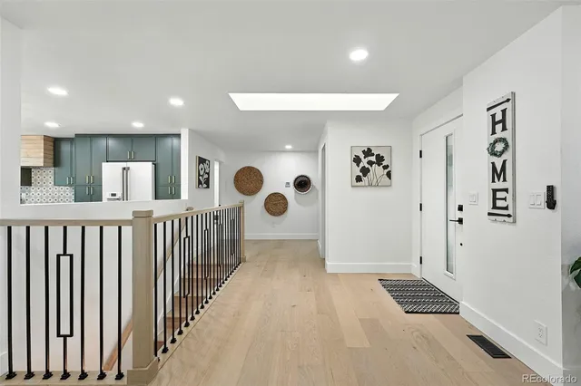 a view of a hallway with wooden floor and windows