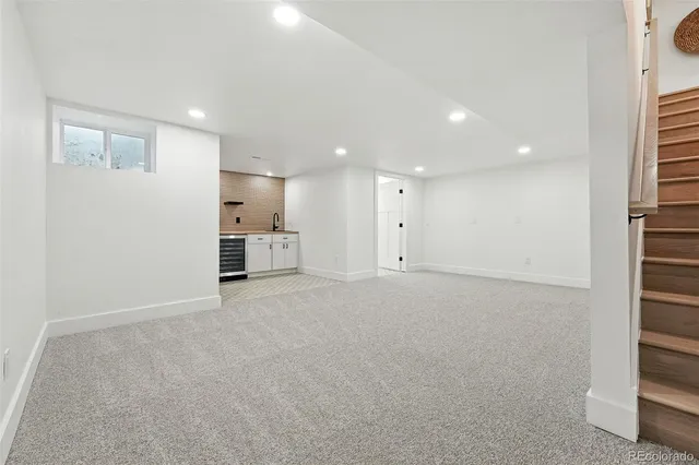 a view of an empty room and a kitchen