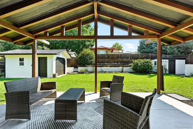 a view of a patio with couches chairs and a yard