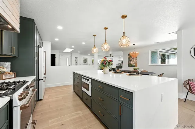 a kitchen with kitchen island a sink stove and refrigerator
