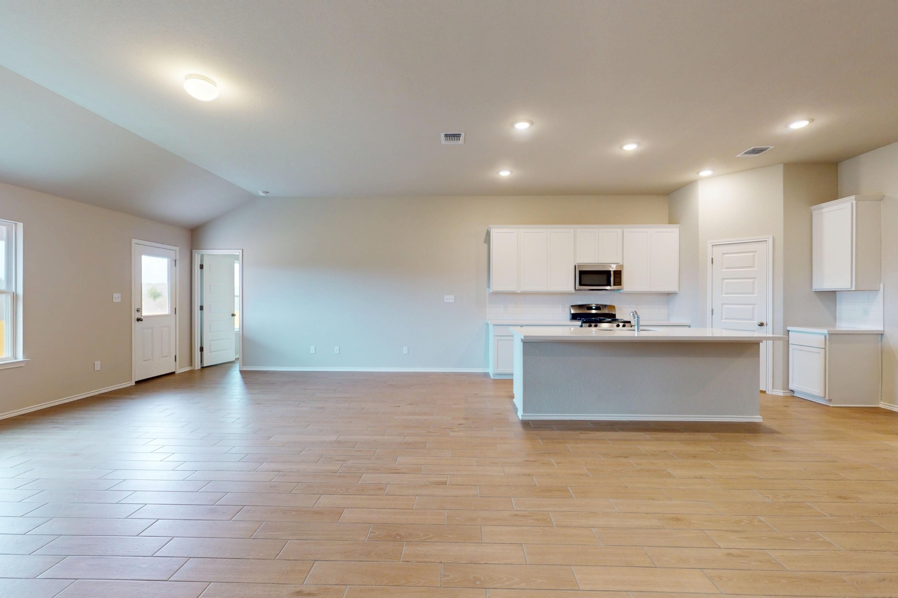 19913 Schatz Way Manor, TX 78653 - Photo 5 of 37 an open kitchen with white cabinets and stainless steel appliances