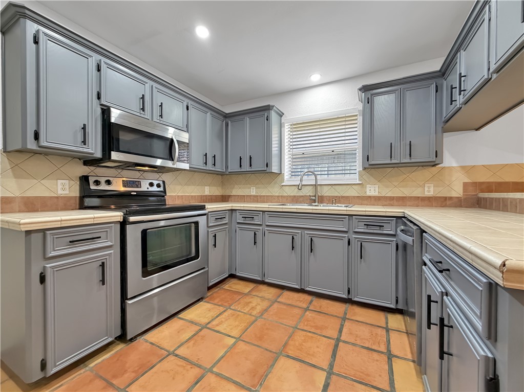 4214 Valley Circle Corpus Christi, TX 78413 - Photo 3 of 28 a kitchen with stainless steel appliances a stove sink microwave and cabinets