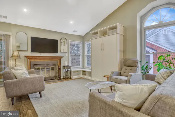 a living room with furniture a fireplace and a flat screen tv