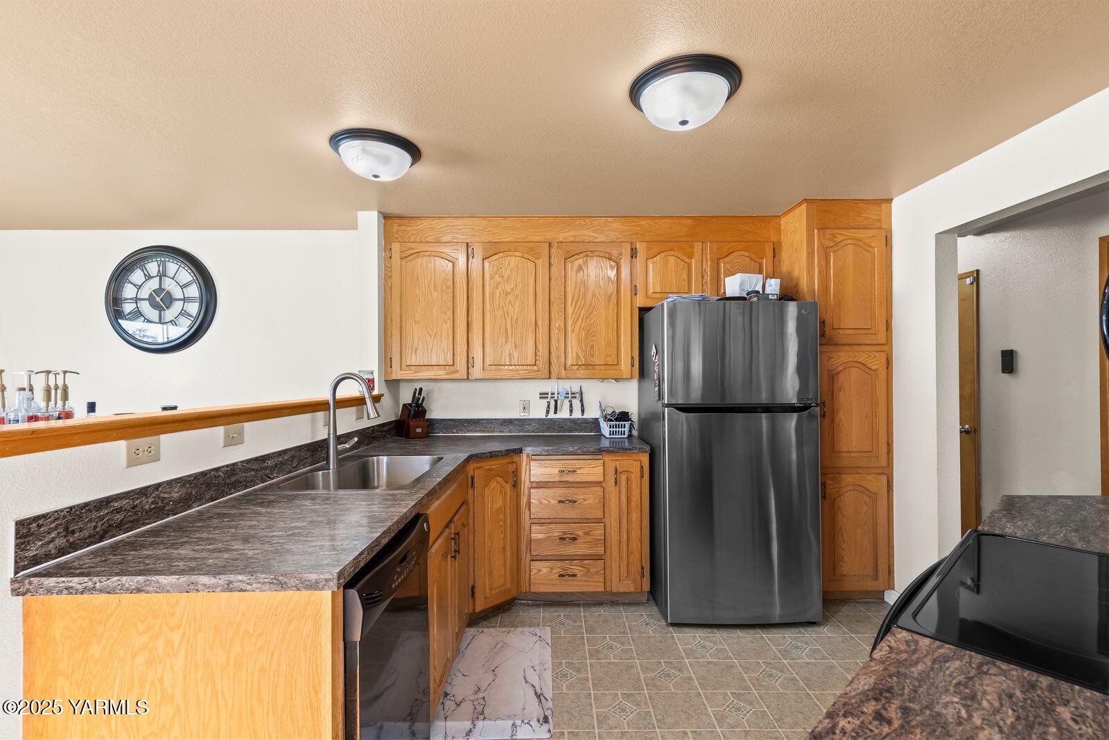 307 South 76th Avenue Yakima, WA 98908 - Photo 11 of 36 a kitchen with refrigerator a stove a sink and a refrigerator