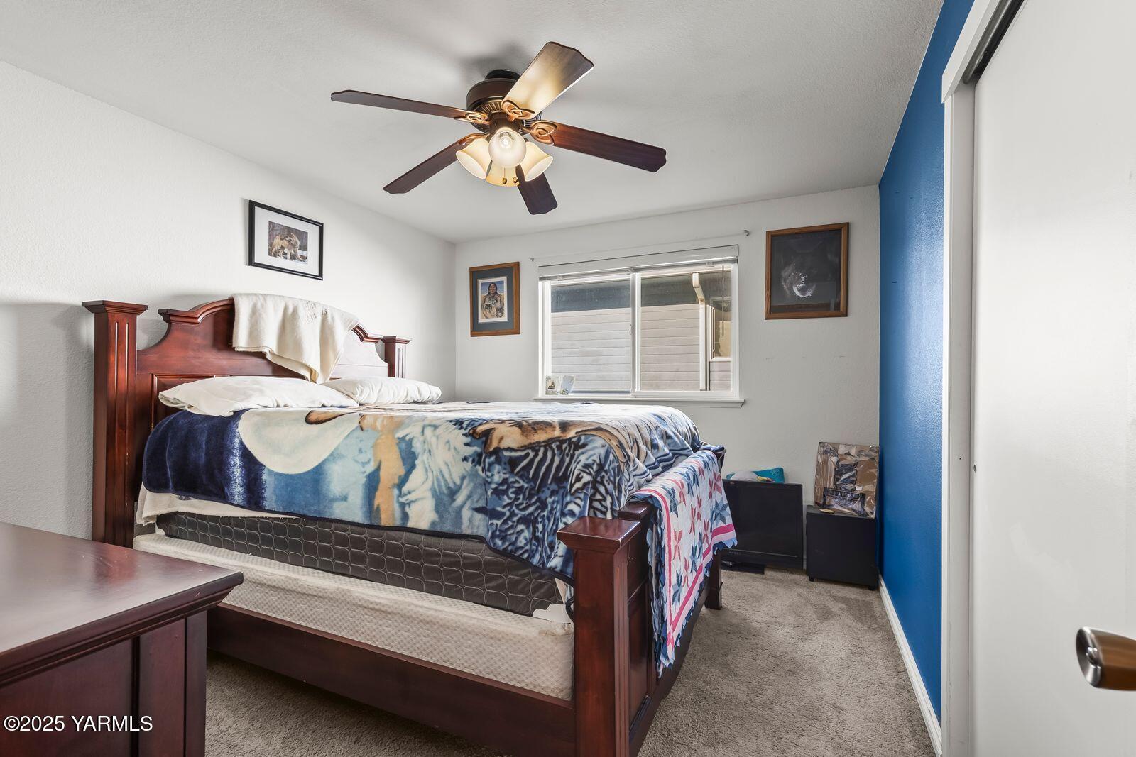 307 South 76th Avenue Yakima, WA 98908 - Photo 20 of 36 a bedroom with a bed and a chandelier