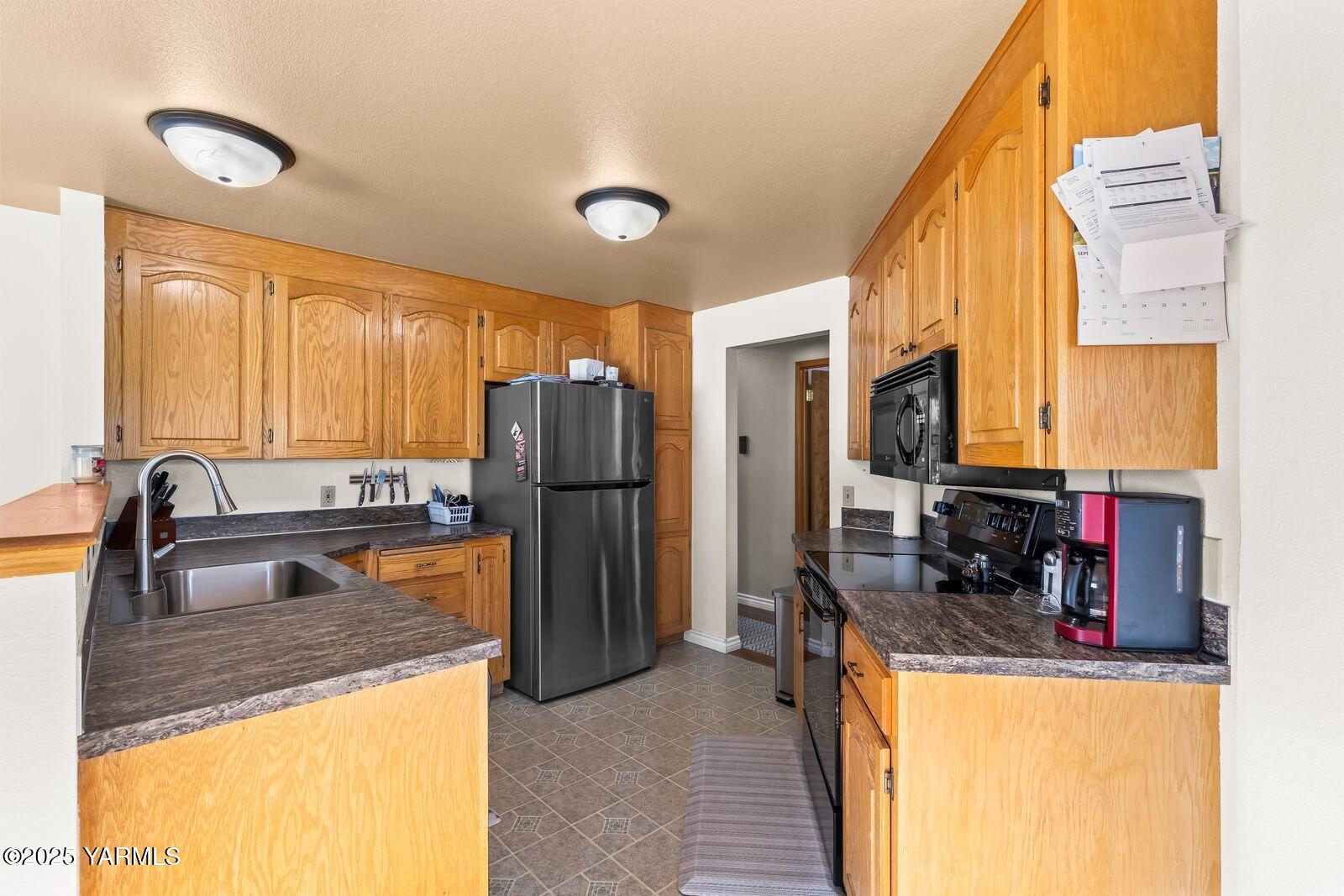 307 South 76th Avenue Yakima, WA 98908 - Photo 6 of 36 a kitchen with refrigerator and cabinets