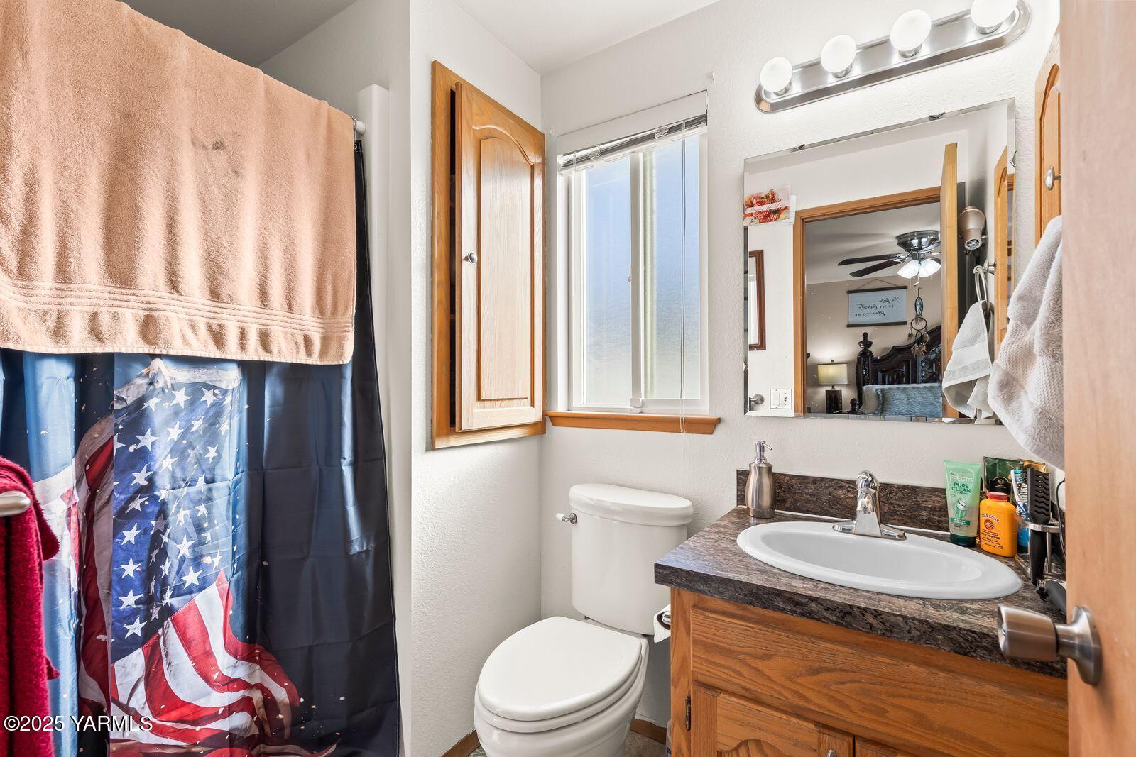307 South 76th Avenue Yakima, WA 98908 - Photo 9 of 36 a bathroom with a granite countertop sink and a toilet