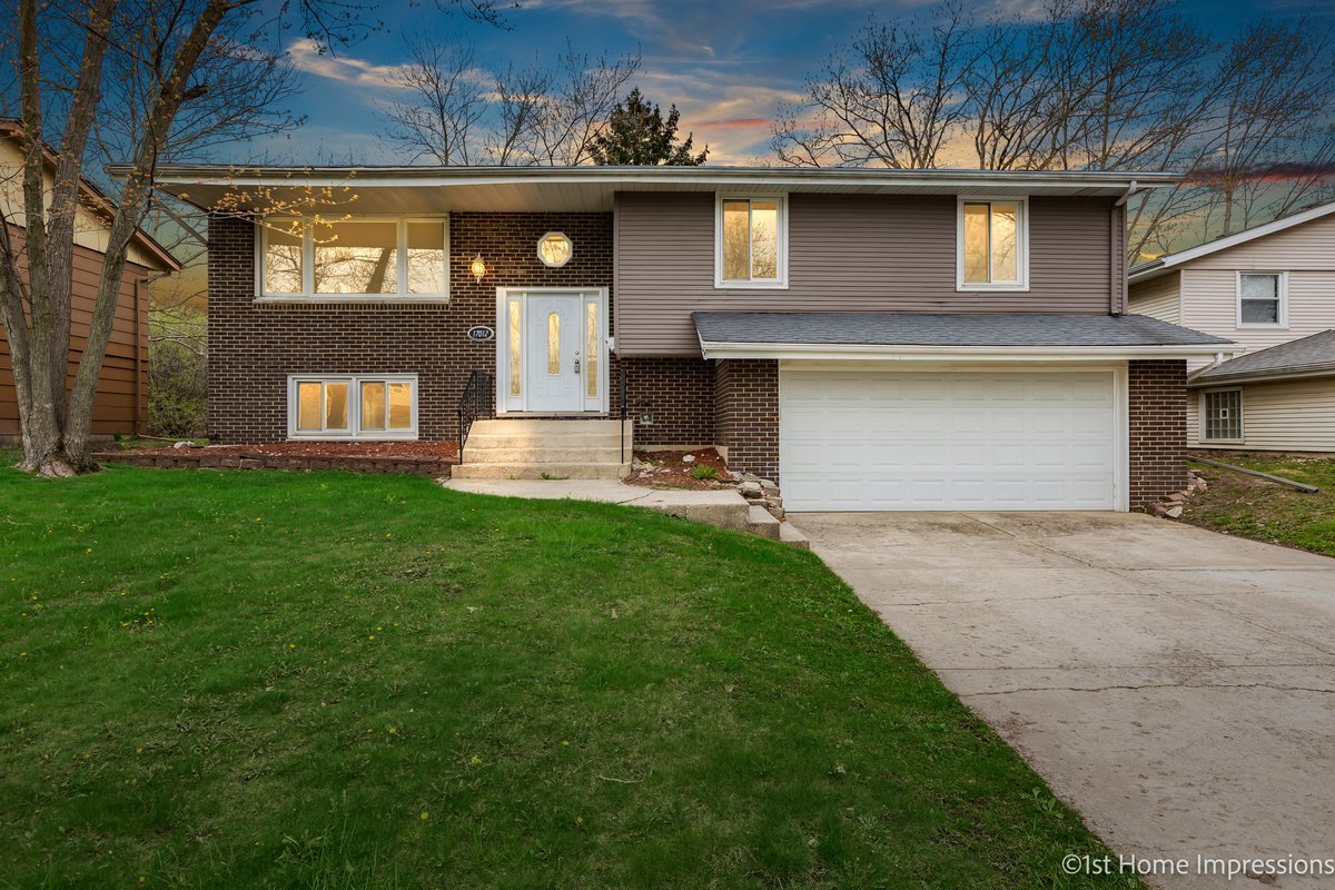 a front view of a house with a yard and garage