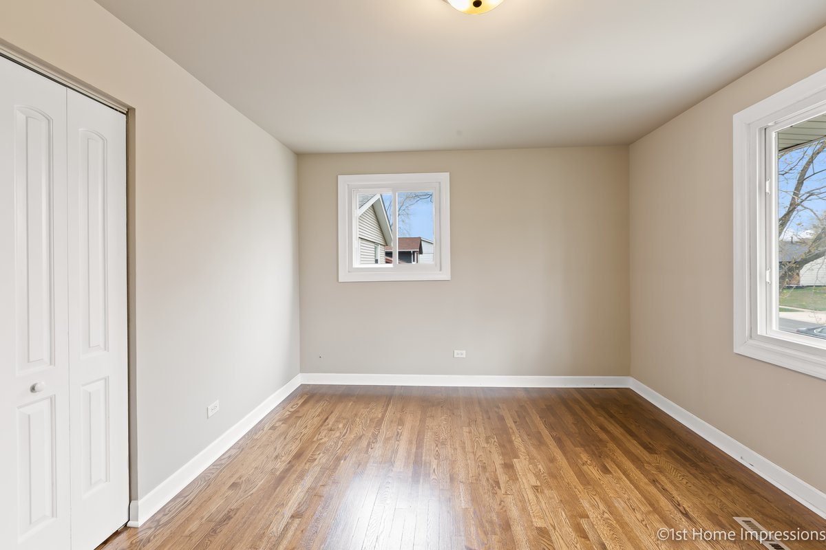 17012 Magnolia Drive Hazel Crest, IL 60429 - Photo 12 of 23 an empty room with wooden floor and windows