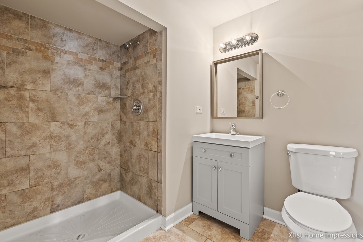 17012 Magnolia Drive Hazel Crest, IL 60429 - Photo 18 of 23 a bathroom with a toilet a sink a mirror and vanity