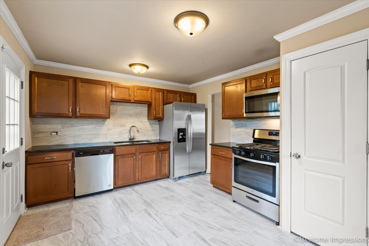 17012 Magnolia Drive Hazel Crest, IL 60429 - Photo 2 of 23 a kitchen with stainless steel appliances granite countertop a stove sink and refrigerator