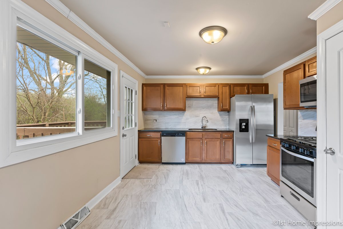 17012 Magnolia Drive Hazel Crest, IL 60429 - Photo 4 of 23 a large kitchen with a large window a sink and stainless steel appliances