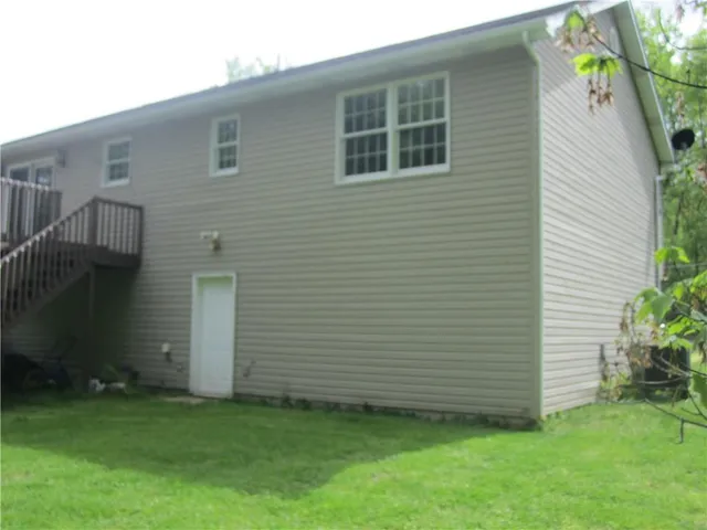 a view of a backyard with potted plants and a large tree