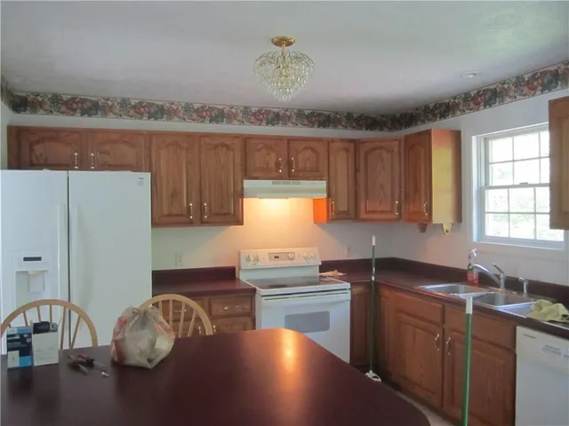 a kitchen with granite countertop a stove a sink and a microwave
