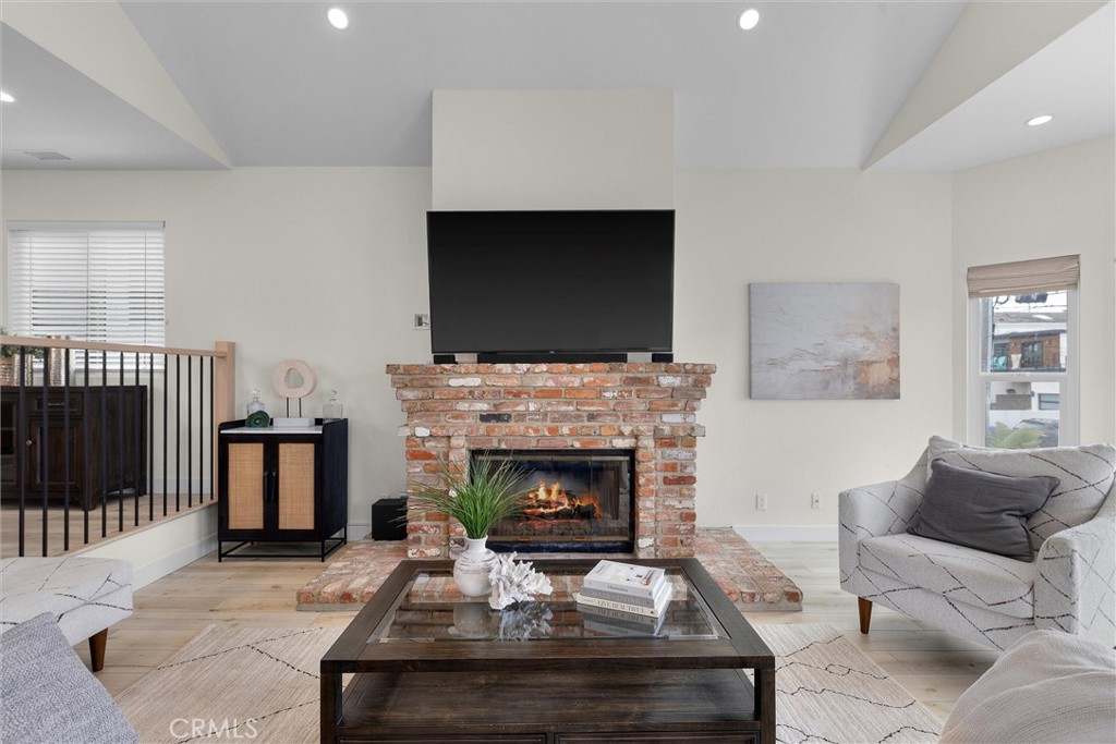1727 Spreckels Lane Redondo Beach, CA 90278 - Photo 3 of 35 a living room with furniture a flat screen tv and a fireplace