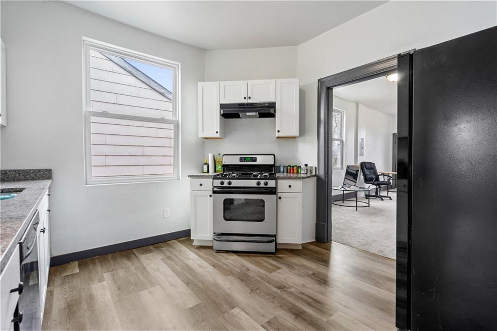 1306 Complete Street Pittsburgh, PA 15212 - Photo 16 of 24 a kitchen with a stove and white cabinets