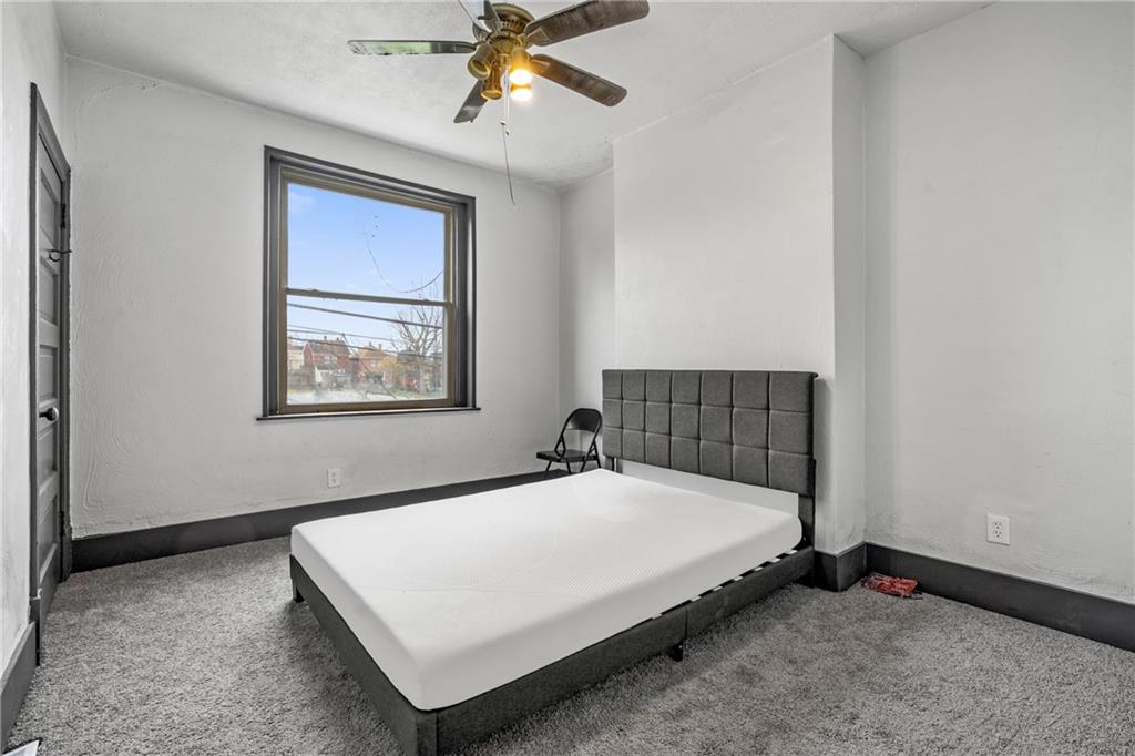 1306 Complete Street Pittsburgh, PA 15212 - Photo 17 of 24 a bed sitting in a bedroom next to a window
