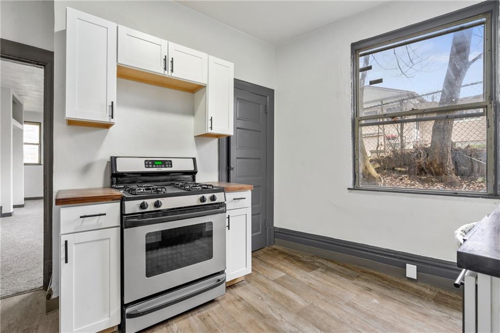 1306 Complete Street Pittsburgh, PA 15212 - Photo 4 of 24 a kitchen with a stove and a wooden floor