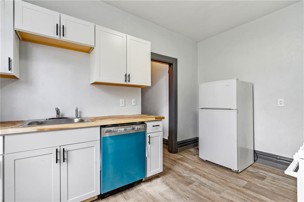 1306 Complete Street Pittsburgh, PA 15212 - Photo 10 of 24 a kitchen with stainless steel appliances granite countertop a refrigerator a sink and a stove