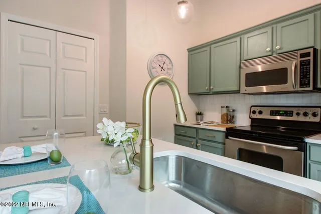 a kitchen with stainless steel appliances granite countertop a stove a sink and a microwave
