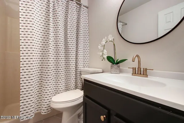 a bathroom with a sink a toilet and a mirror