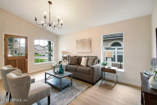 a living room with furniture chandelier and a window
