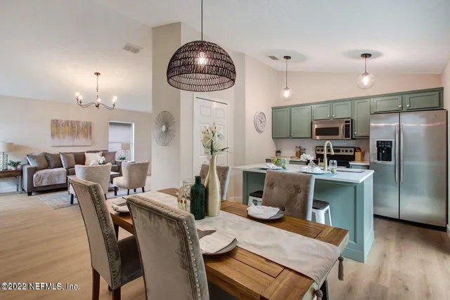 a kitchen with a dining table chairs stainless steel appliances and cabinets