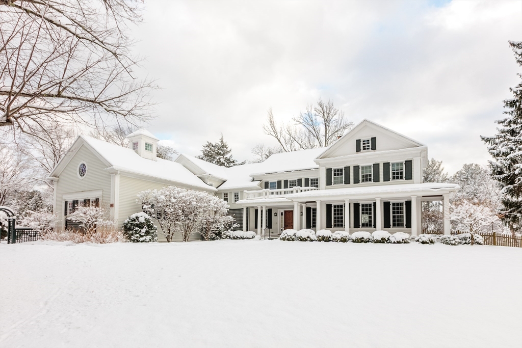 a front view of a house with a yard covered with snow