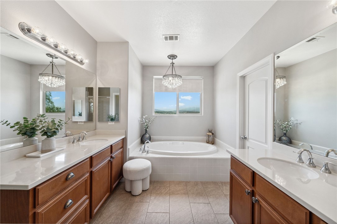 39148 Steeplechase Lane Temecula, CA 92591 - Photo 33 of 65 a spacious bathroom with a bathtub double sink shower and a mirror