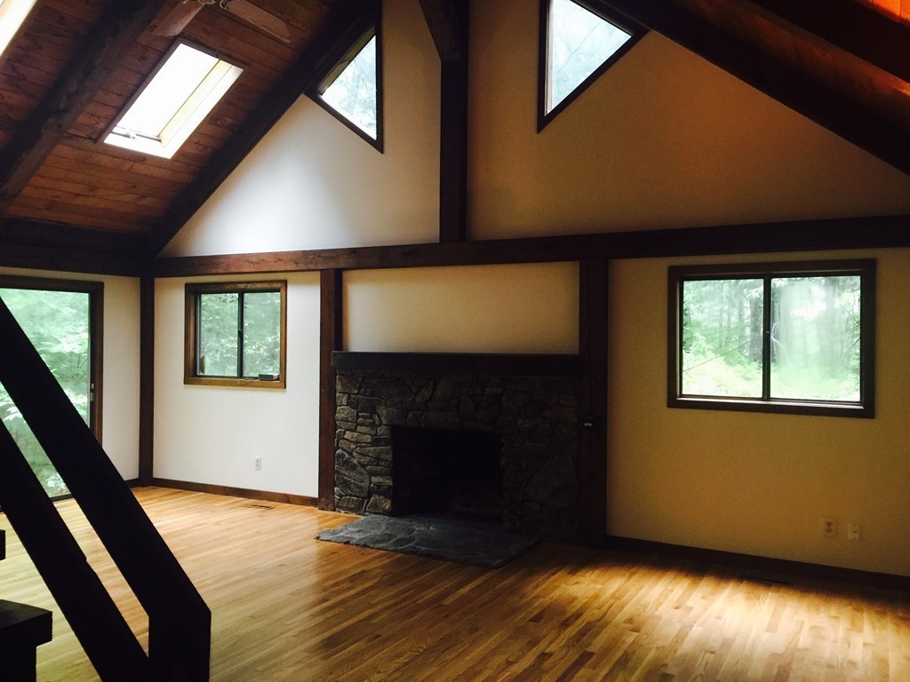 231 Still River Road Bolton, MA 01740 - Photo 6 of 19 a view of an empty room with wooden floor and a window