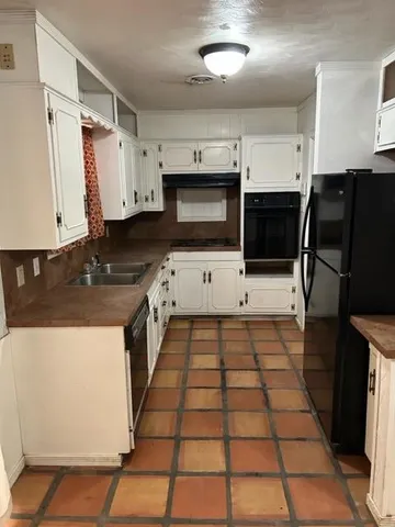 a kitchen with granite countertop a stove a sink and a microwave
